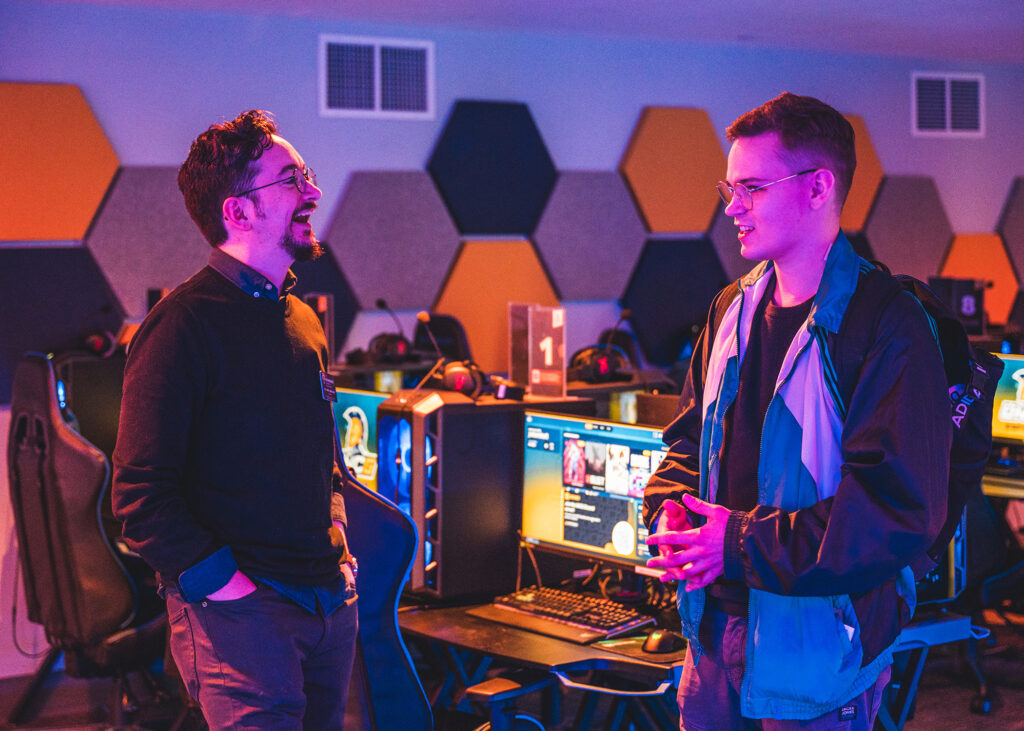 Professor talks to a student in the esports arena.