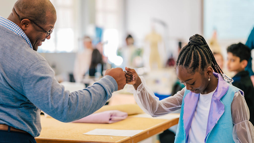 Oak View Elementary principal Bennie Bradley fist bumps student Ivy Bennett.