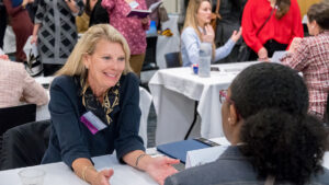 Dr. Terri Shelton speaks to a UNCG student at a table.