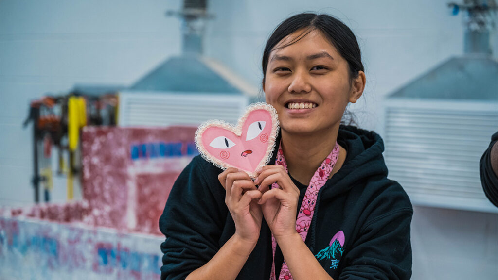 A UNCG student holds up a Valentine made with the Artists' Guild.