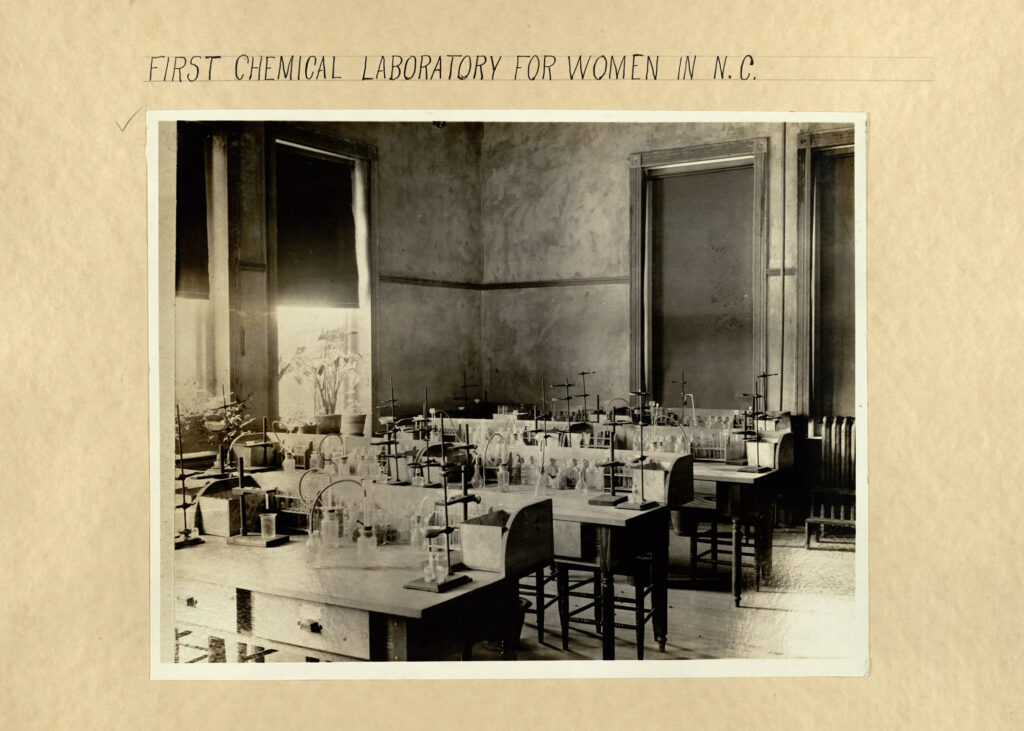 Scrapbook from 1892 showing the first chem lab at UNCG - tables and chairs with beakers and test tubes.