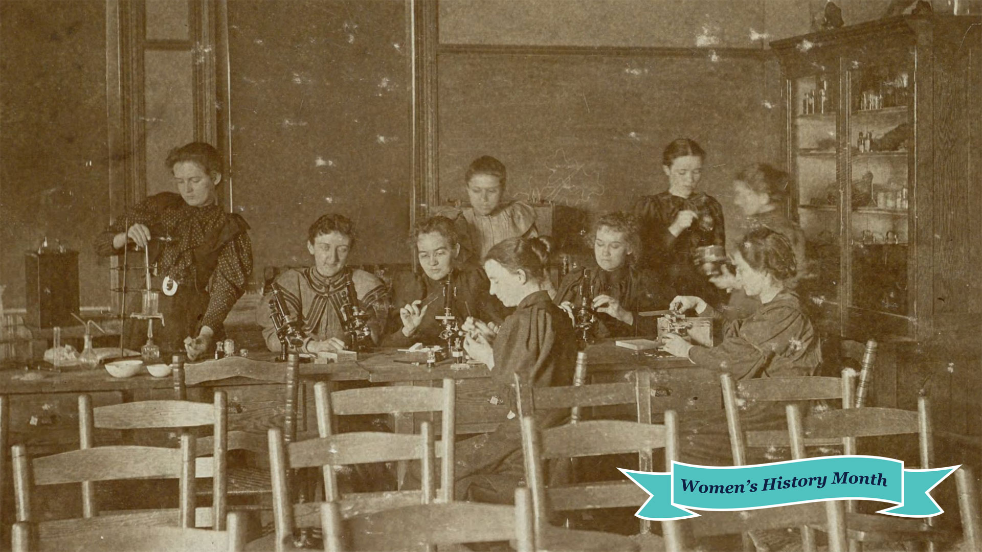 Sepia image of women in a science class in 1892 - working with microscopes.