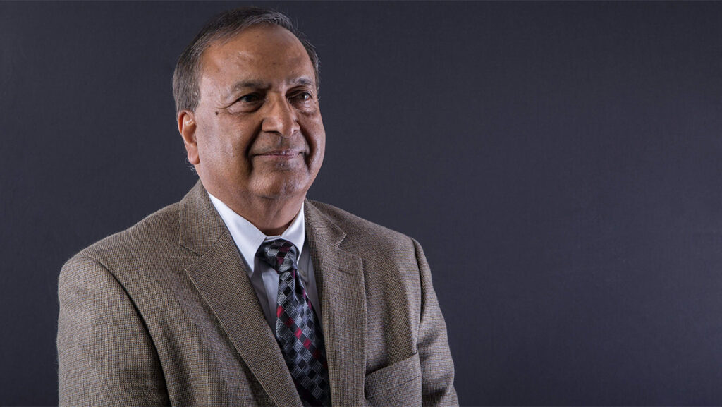 A headshot of a man in a gray suit.