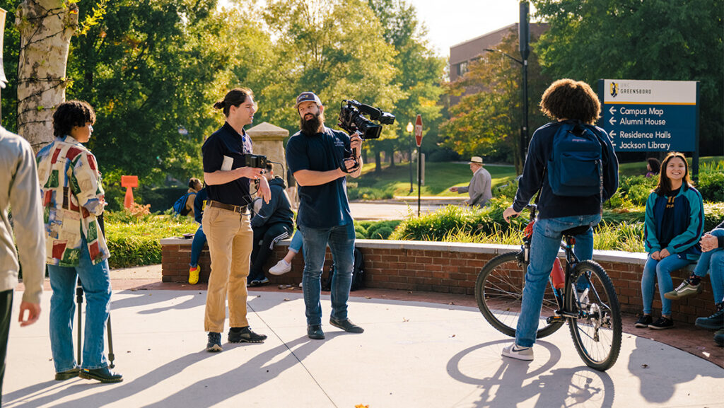 UNCG videographers David Row and Grant Gilliard record a scene outside on campus.