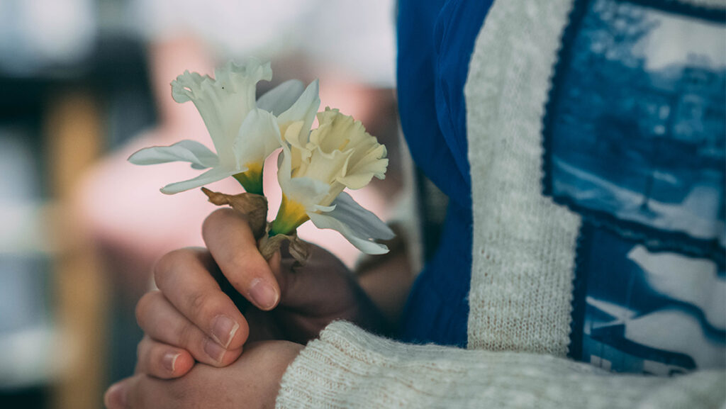 UNCG photography student Ariel Avants holds a sprig of flowers.