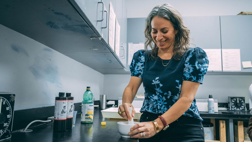 UNCG photography associate professor Leah Sobsey crushes flowers for anthotype photography.