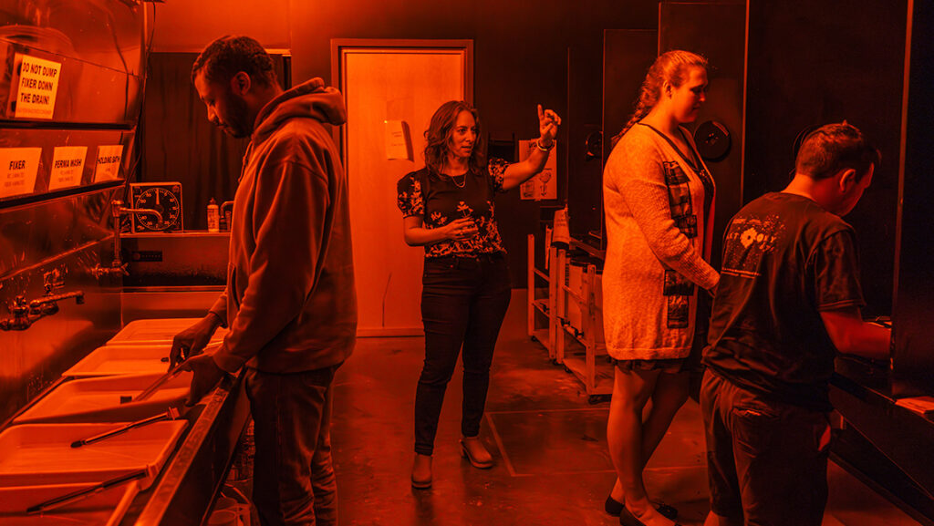 UNCG photography associate professor Leah Sobsey leads a demonstration in the darkroom.
