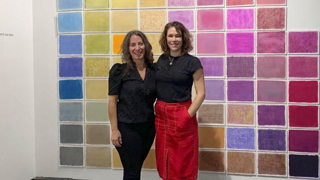 UNCG associate professor of photography Leah Sobsey with collaborator Amanda Marchand stand beside their Emily Dickinson photography exhibit.