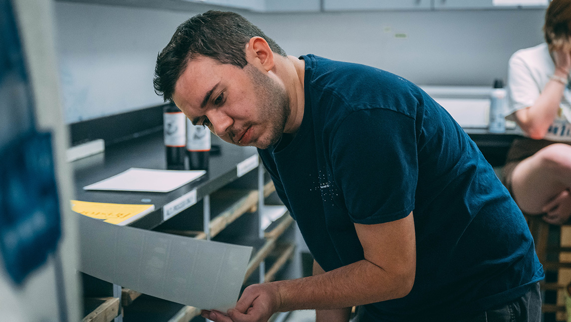 UNCG media studies student Jay Garner looks at a photograph.