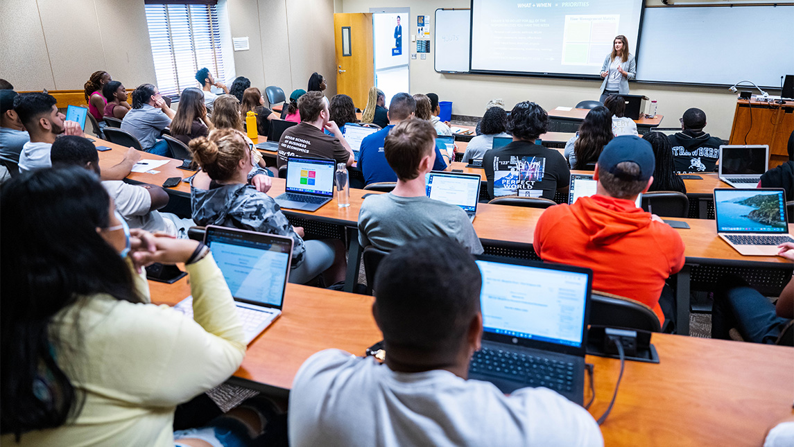 Students sit in a lecture hall during a UNCG business class.