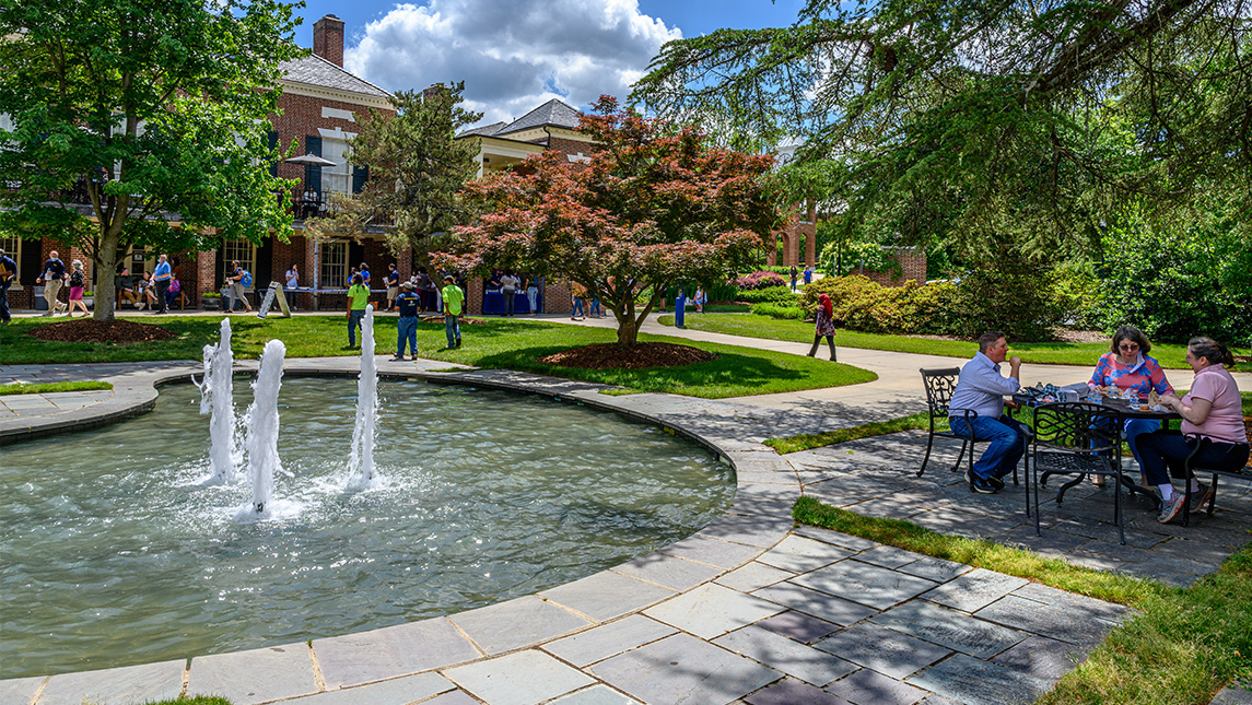 UNCG staff sit around tables for an appreciation luncheon near the fountain in Taylor Garden.