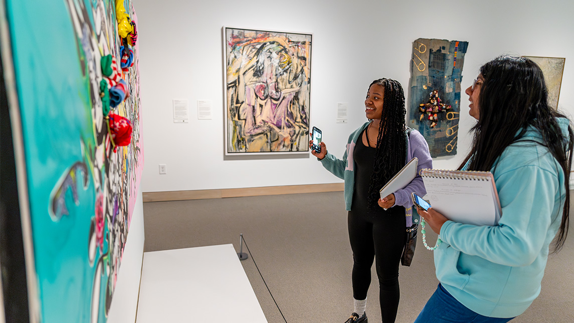 Students from UNCG look at artwork in the Weatherspoon Art Museum.