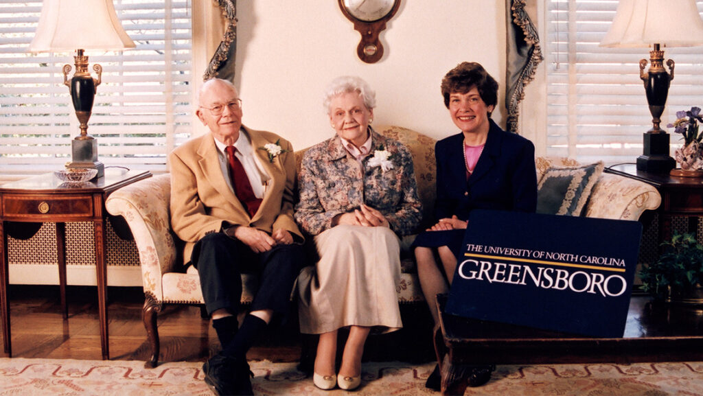 UNCG Chancellor Pat Sullivan sits on a couch with two other people.