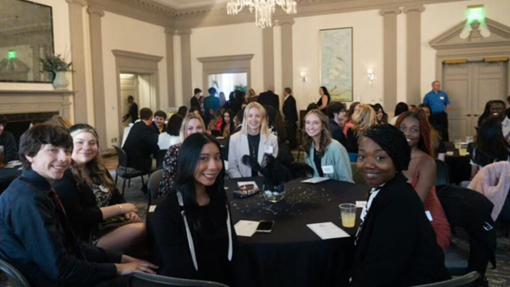UNCG students smile from their seats at tables at the MEHT gala.