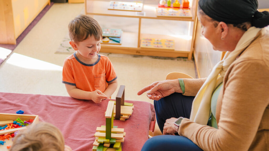 UNCG Child Care Education Program staff member works with a child