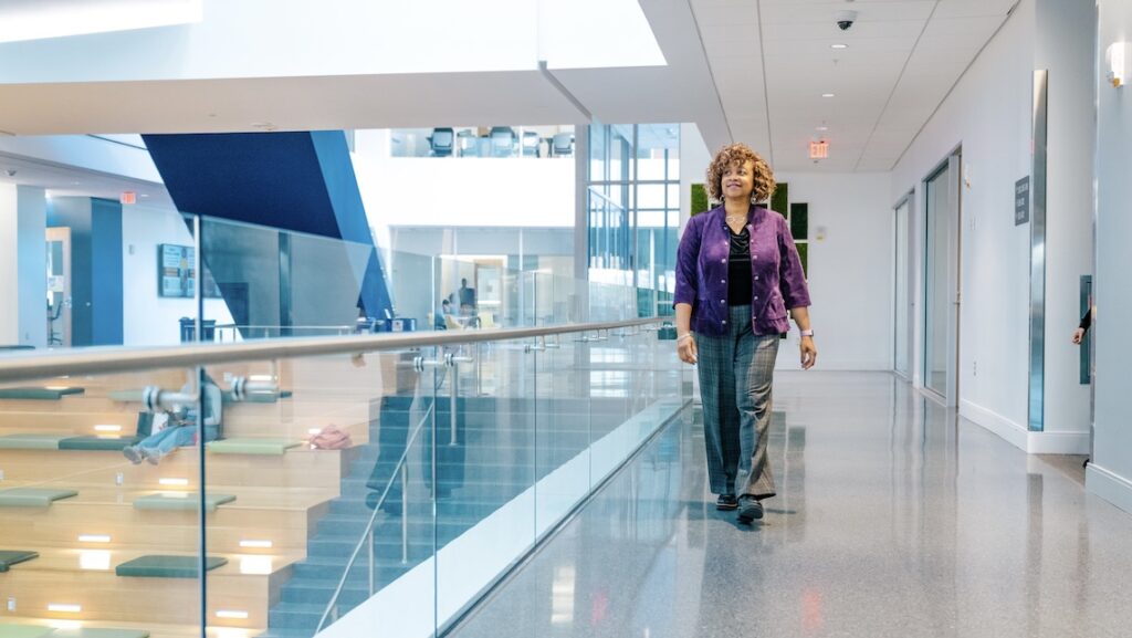 Debra Neblett walking down a hallway in UNCG School of Nursing.
