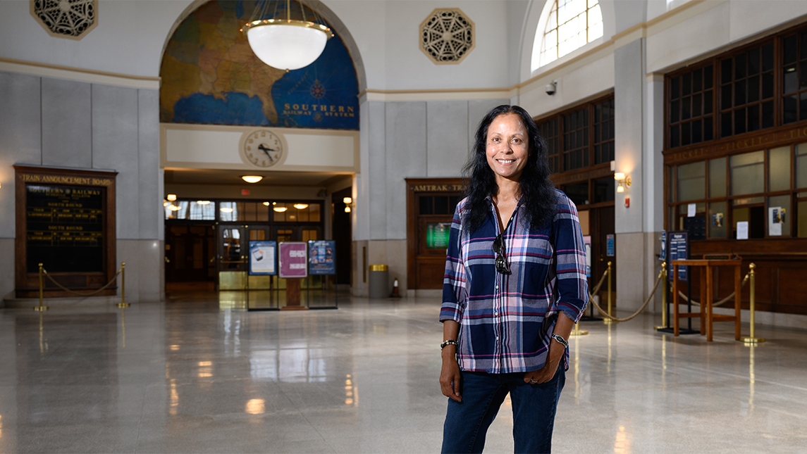 A woman stands in a transportation depot.