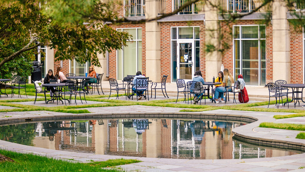Students sit around the reflecting pool of UNCG Taylor Garden.