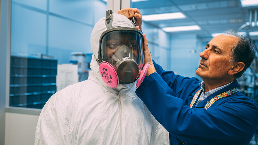 Mahdi Fahim checks the safety of a mask on a UNCG student at JSNN.