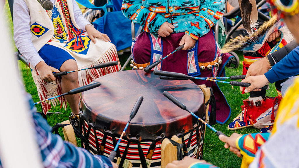 Native Americans drum together at the UNCG powwow.