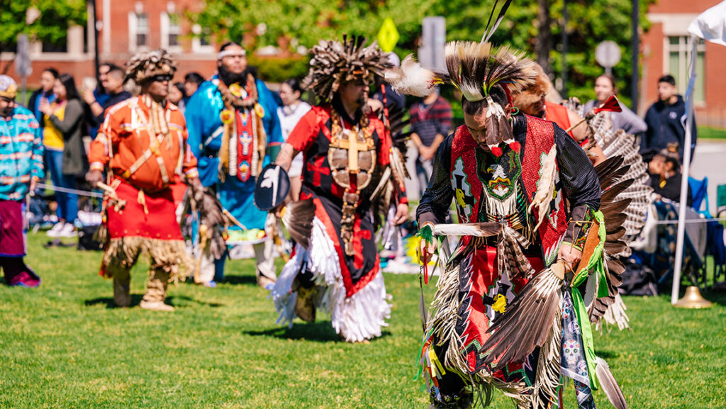 Native American dancers march out on UNCG quad.
