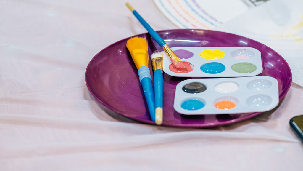 A plate with paint and a brush.