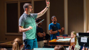 A conductor leads students at UNCG's music camp.