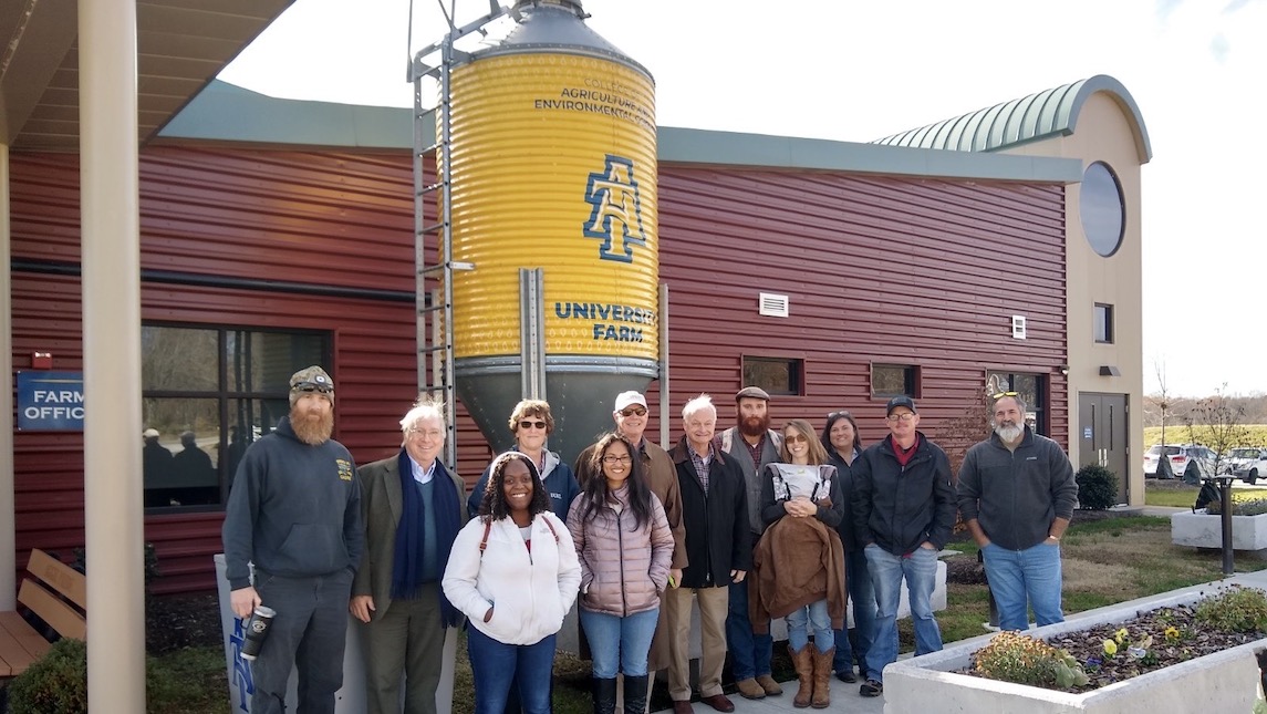 JSNN students stand in front of a silo at University Farms.