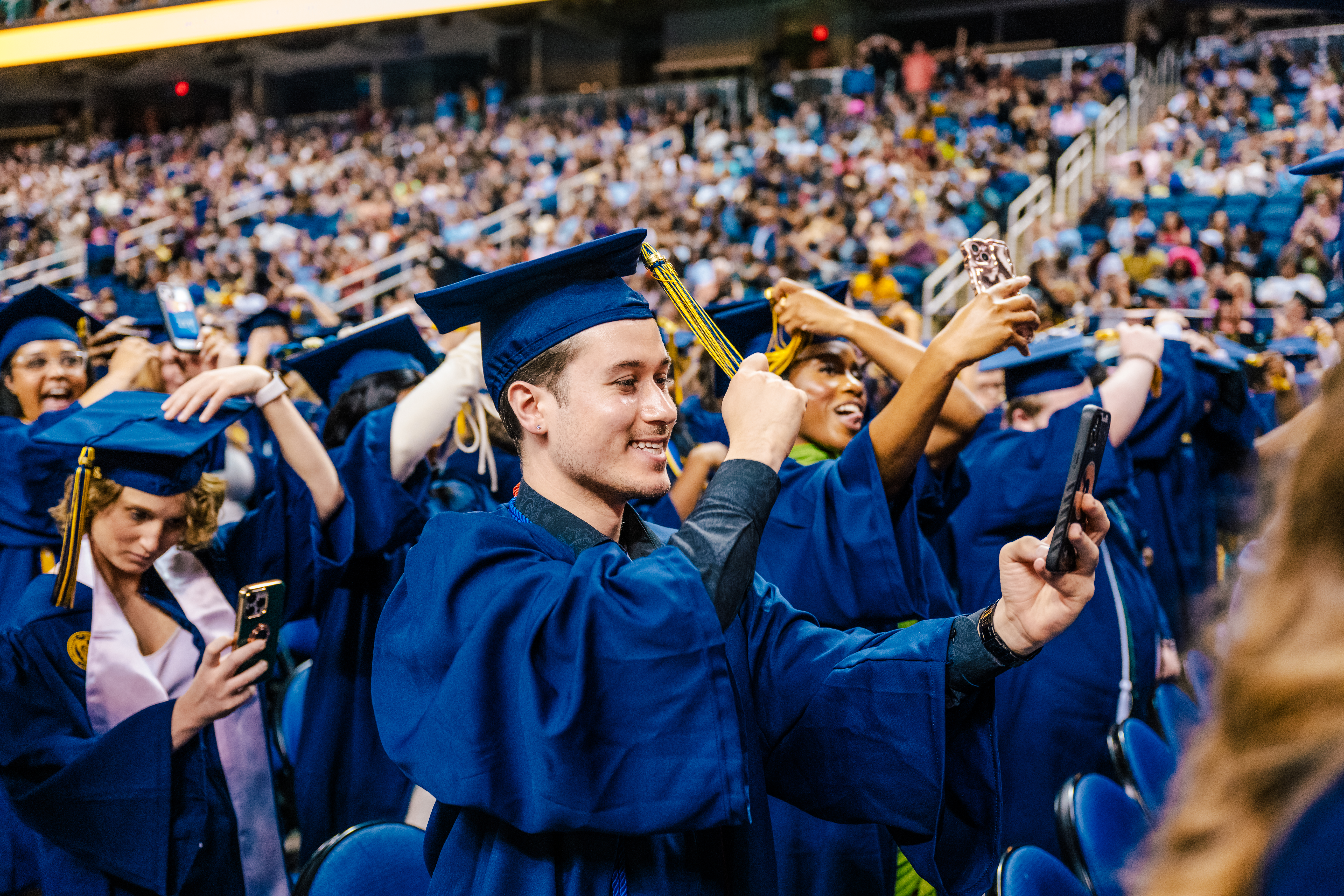 UNCG grads turn their tassels while filming selfies with big smiles!