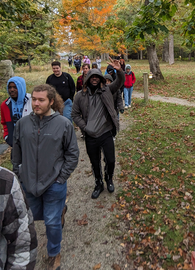 UNCG biology students walk down a forest path.