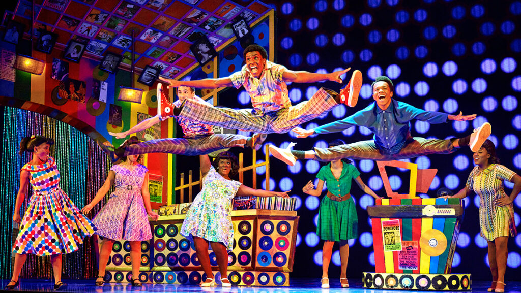 UNCG acting major and "Hairspray!" actor Gabriel Yarborough leaps in the air during a dance on stage.
