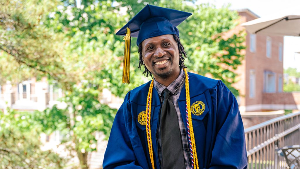 UNCG graduate Adrian Allen ’24 in his cap and gown.
