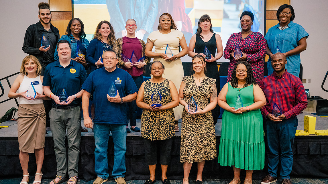 UNCG Student Affairs staff pose in a group holding awards.