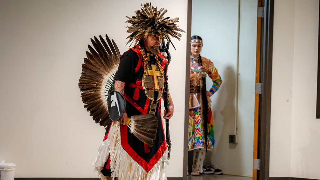 A man models a Native American-inspired outfit at UNCG.