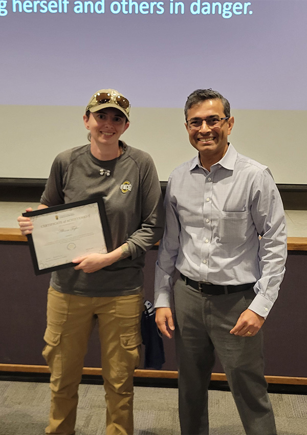 UNCG facilities associate vice chancellor Sameer Kapileshwari gives an award to Alison Tighe.
