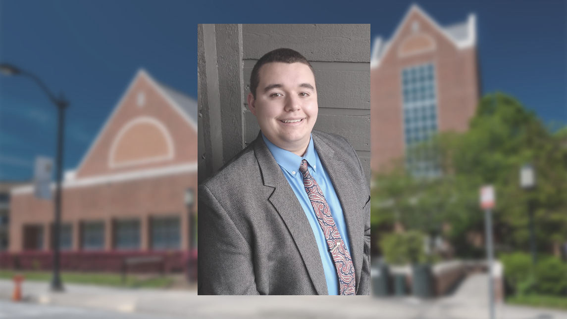 Headshot of UNCG staffmember Grant Harris against backdrop of Walker Parking Deck.