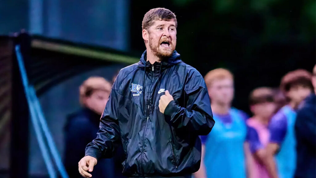 Josh Horne, new assistant coach for UNCG men's soccer, walks on the field.