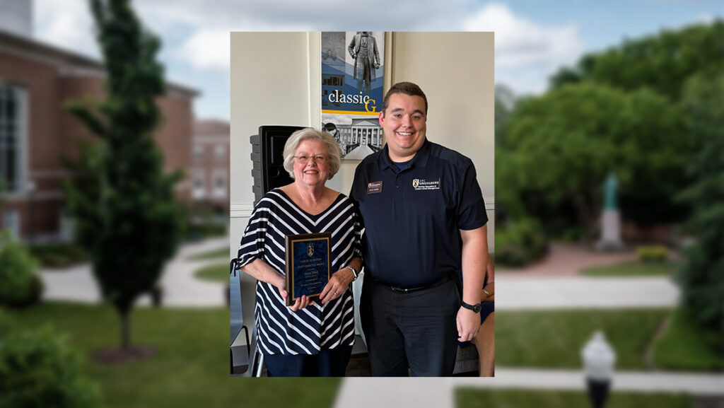 Grant Harris presents a UNCG award plaque to Helen Ward, a retired member of Campus Enterprises.