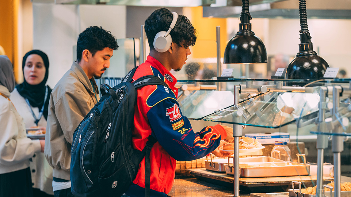 Students line up in the UNCG dining hall to scoop food onto their plates.