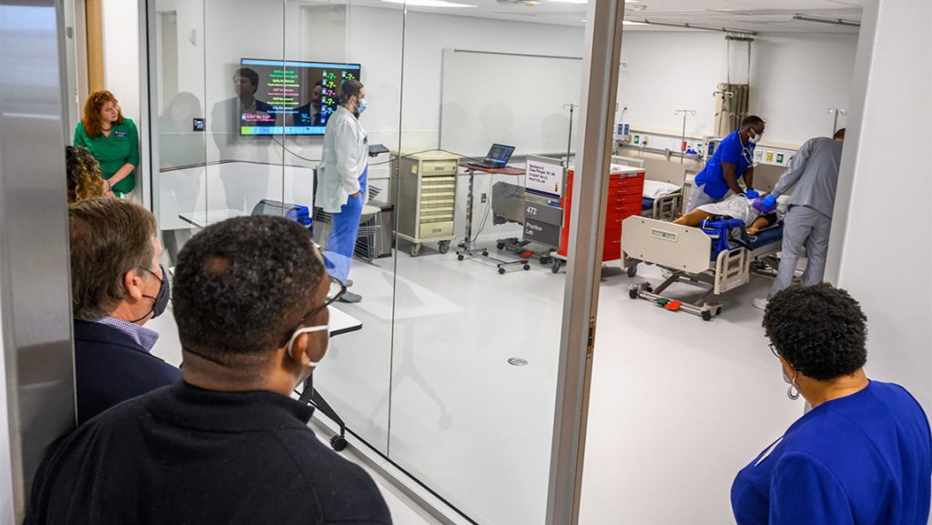 Guests watch UNCG nursing students work in the simulation lab.