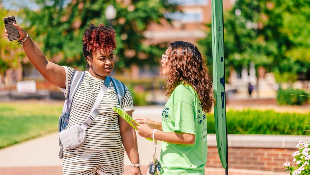 A new UNCG student asks for directions from a SPEAR volunteer.
