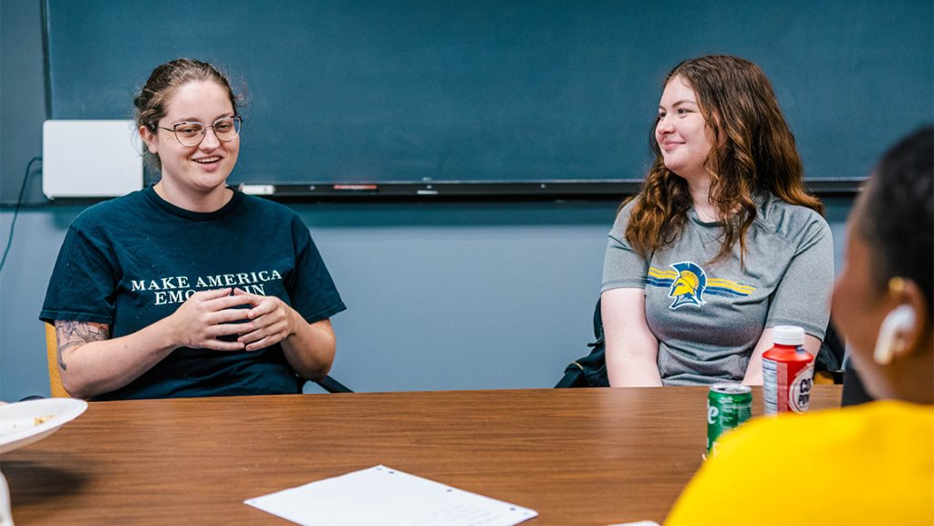 UNCG students chat around a table.