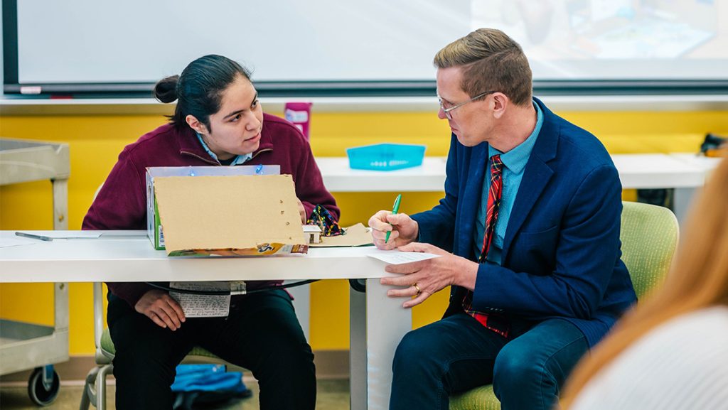 A UNCG School of Education faculty member talks to a student.