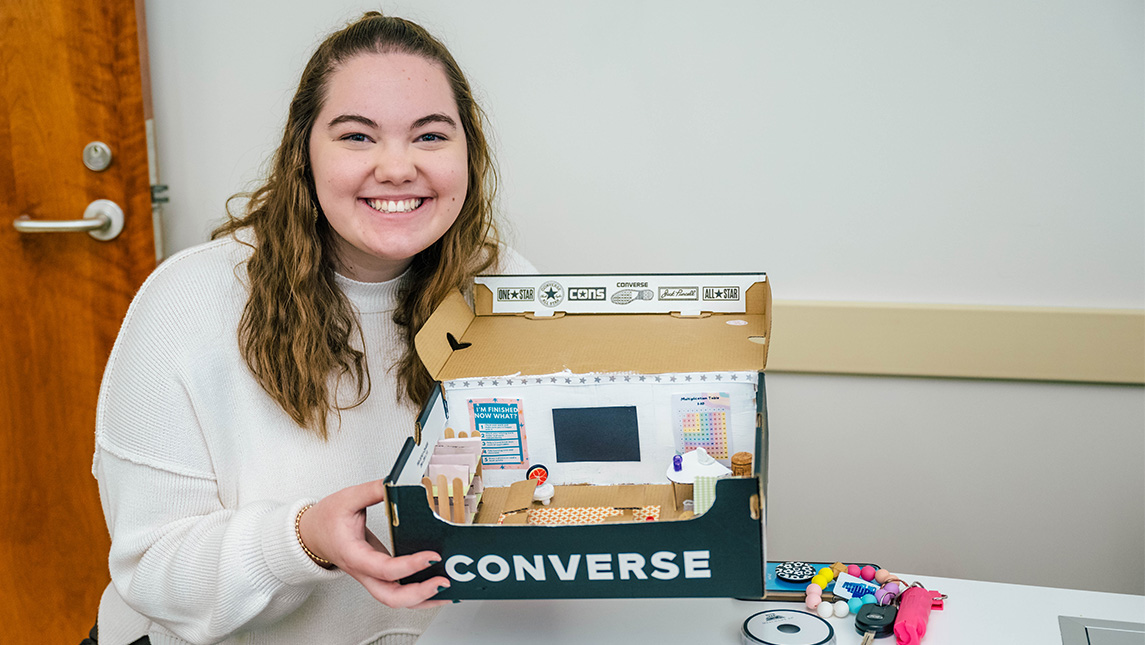 A UNCG student shows off her model of her future classroom space.