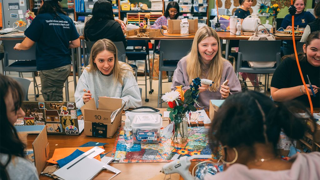 Students laugh while working on cardboard models in the UNCG makerspace.