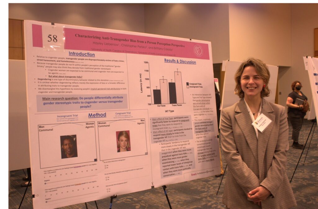 A woman standing by her board presentation during a previous year's showcase.