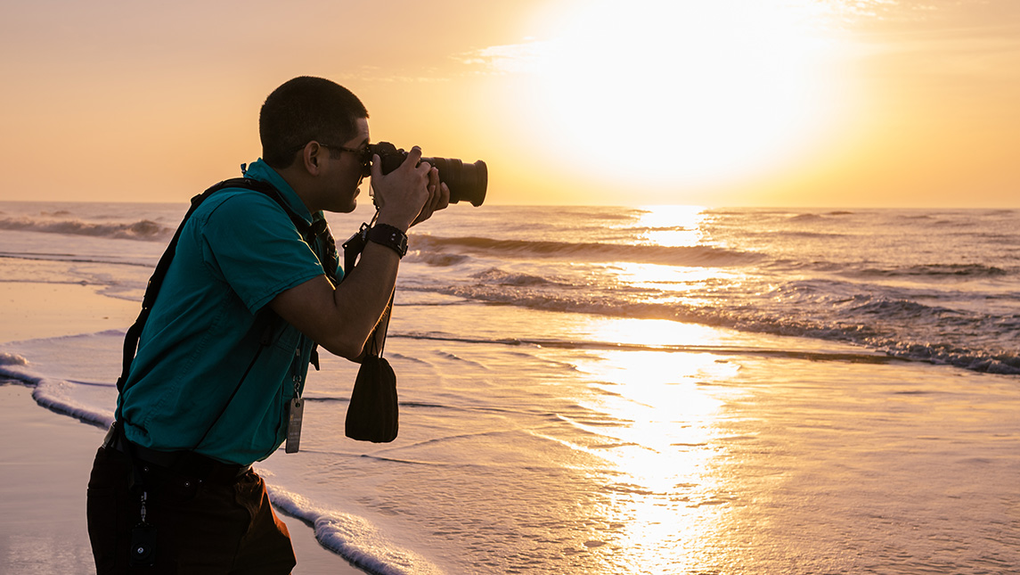 UNCG photographer Sean Norona takes a picture of a beach sunset.