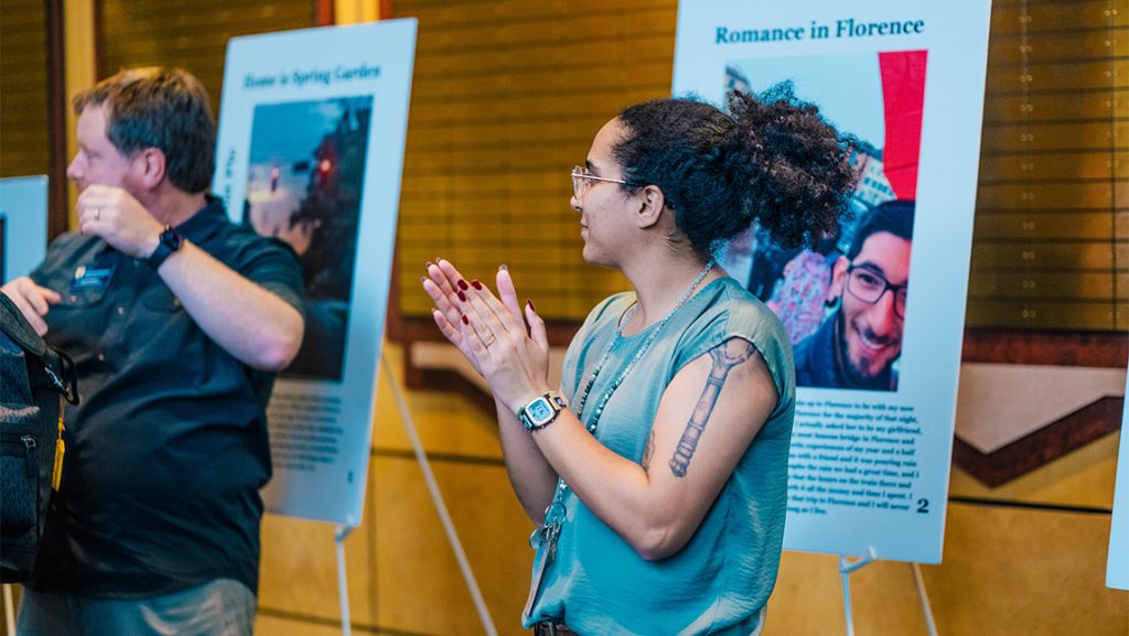 A student stands in front of a poster about Florence during UNCG's International Education Week.