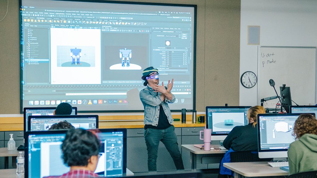 an instructor in front of a screen in the animation lab