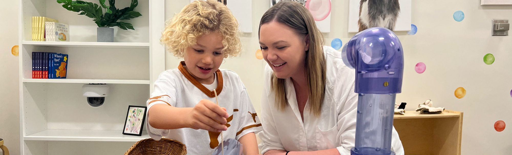 a child is conducting an experiment with a teacher.